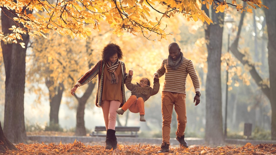 Young African American family walking in a park.