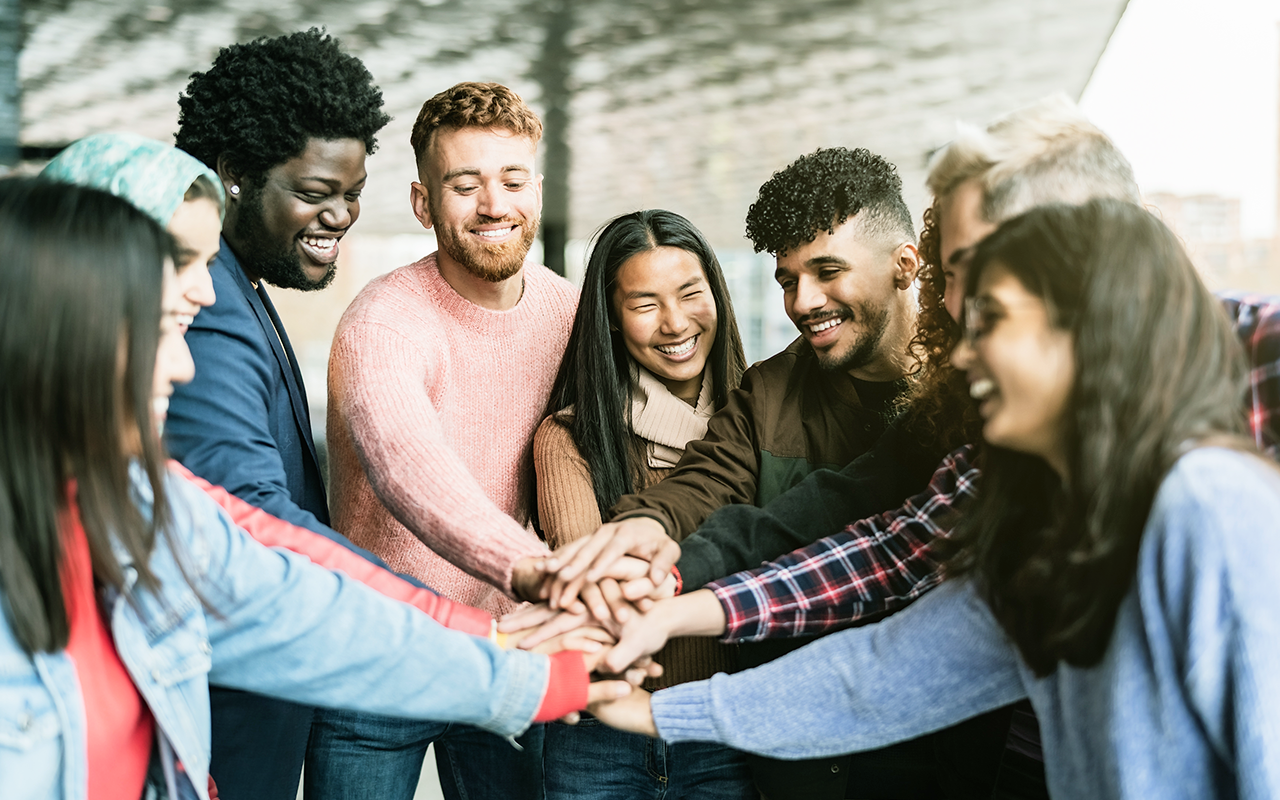 Diverse community members huddle together as a team.